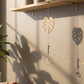monstera leaf shaped suncatcher near a window.